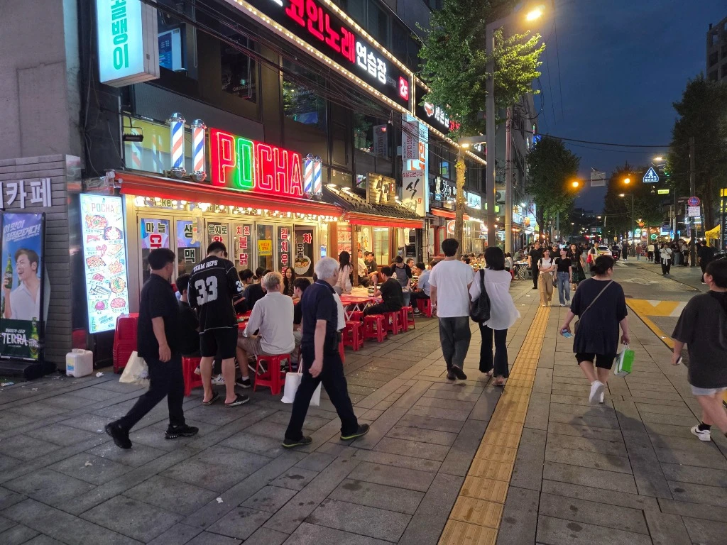 韓國首爾夜生活完全指南2026:弘大夜店、梨泰院酒吧、江南高端會所與24h汗蒸幕全攻略 - 首爾弘大 POCHA 布帳馬車街景與年輕人群不夜城實況